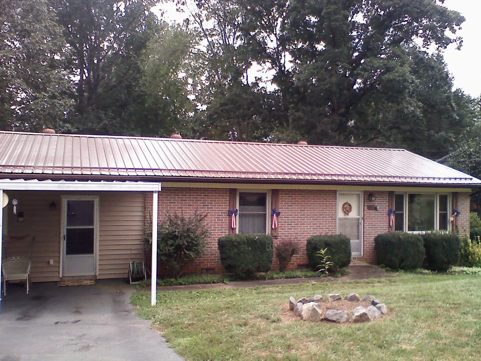 Bronze metal roof and carport on a brick ranch home — Roof Repair work by our crew in Fingerville