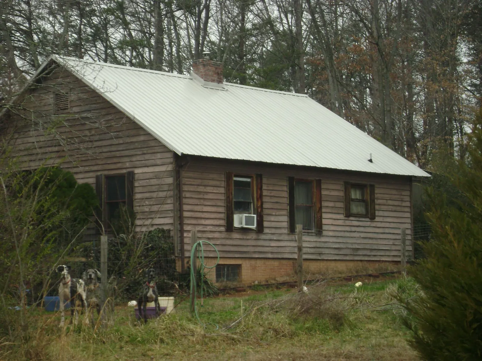 White metal roof on an old wood sided farmhouse, from a Metal Roof Installation job in Fingerville